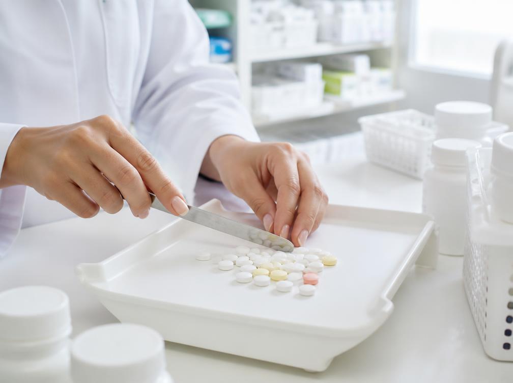 Pharmacy technician sorting pills on a tray